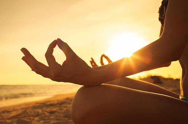 Close-up hand of a woman meditating  on the beach.